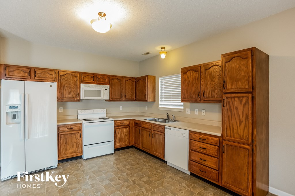 a kitchen with white appliances and wooden cabinets