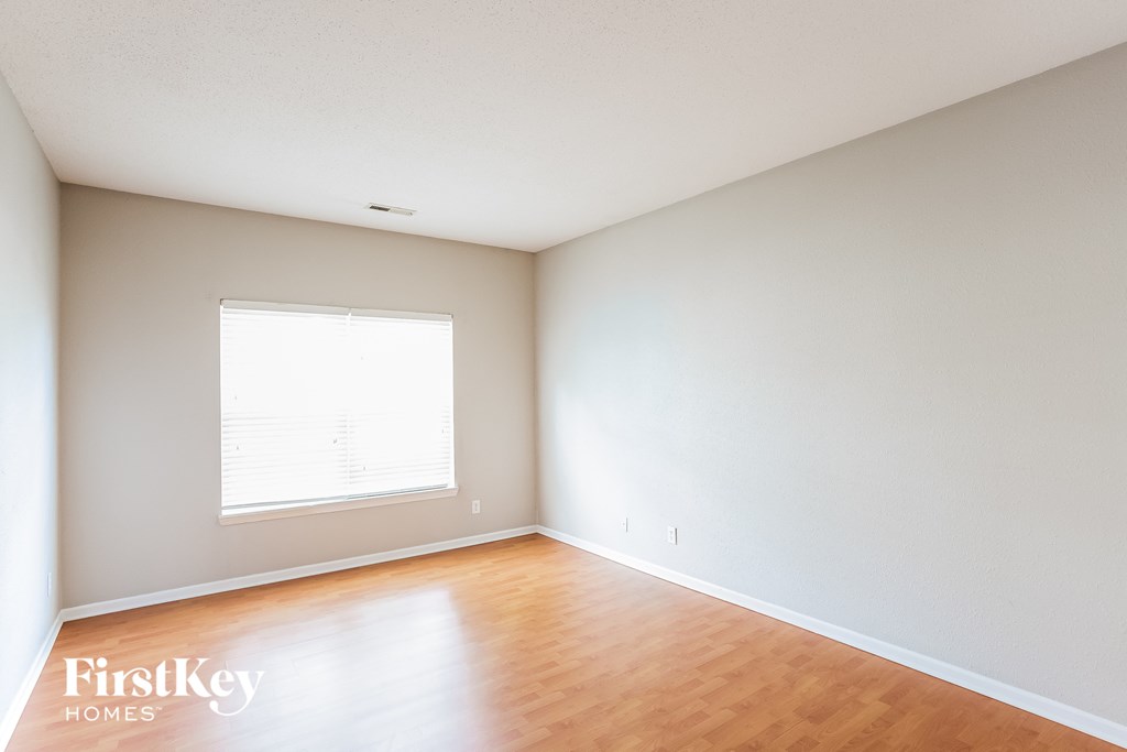an empty room with wooden floors and a window