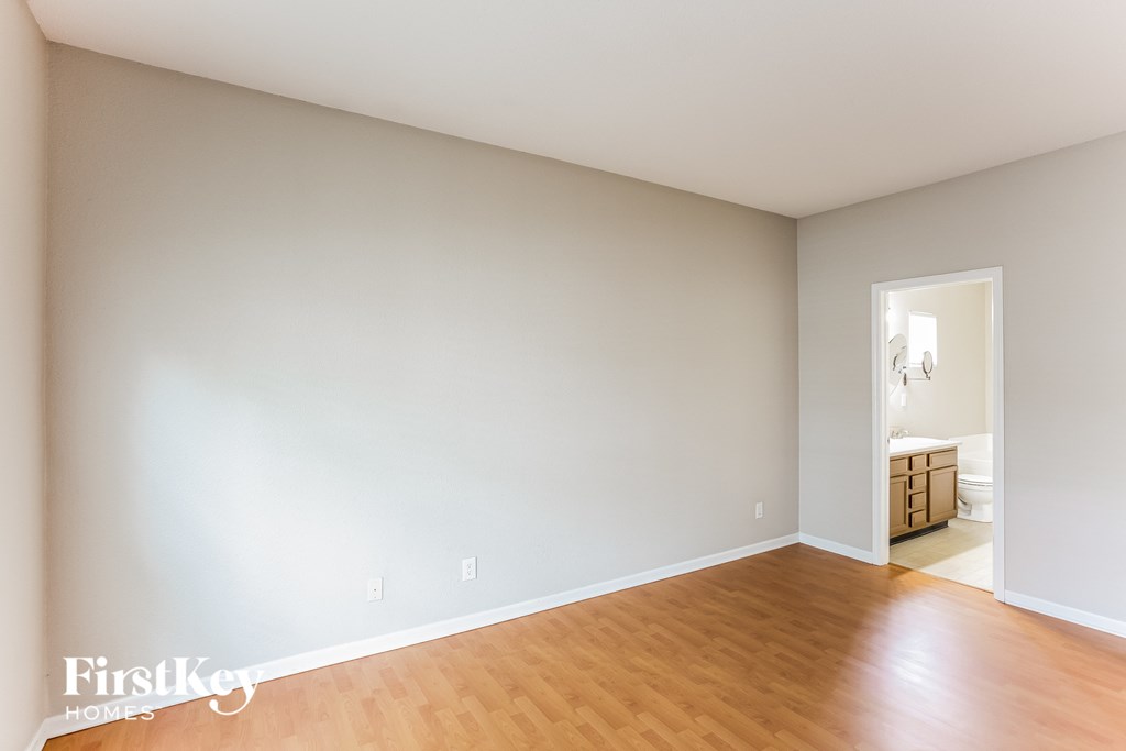 an empty living room with wood flooring and white walls
