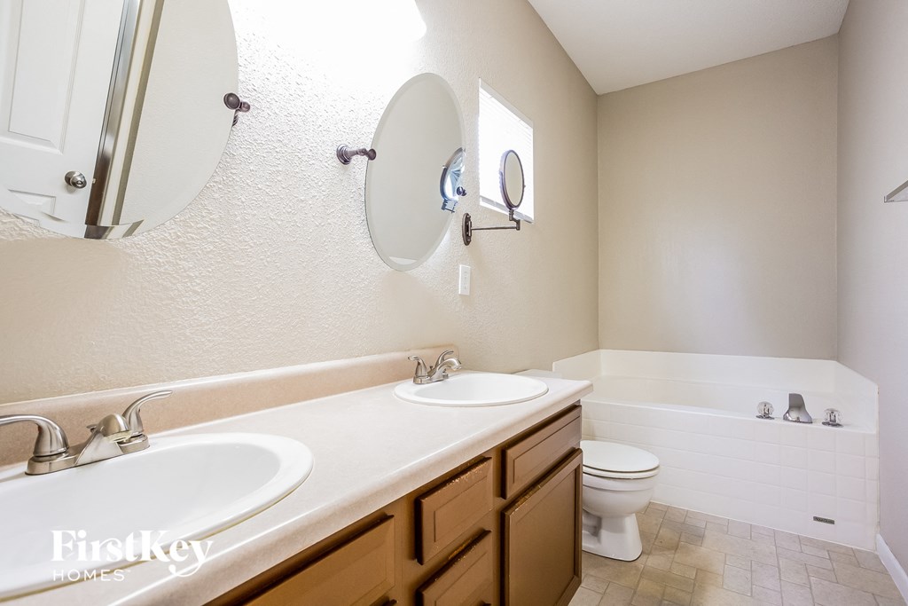 a bathroom with two sinks and a toilet and a tub