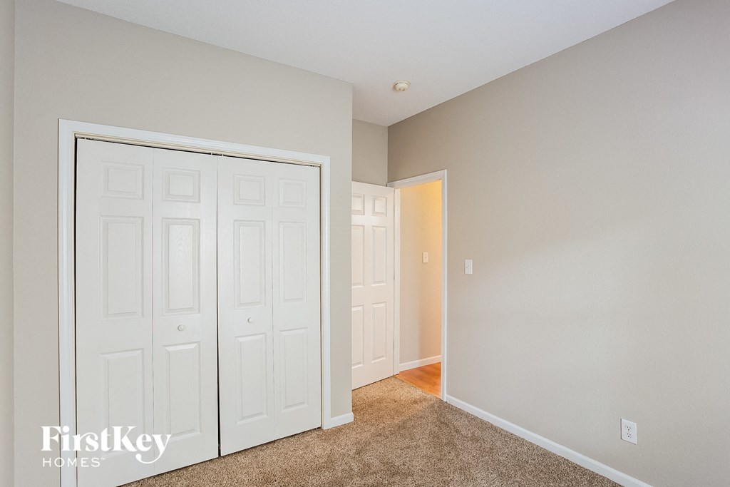 a bedroom with two closets and a door to a hallway