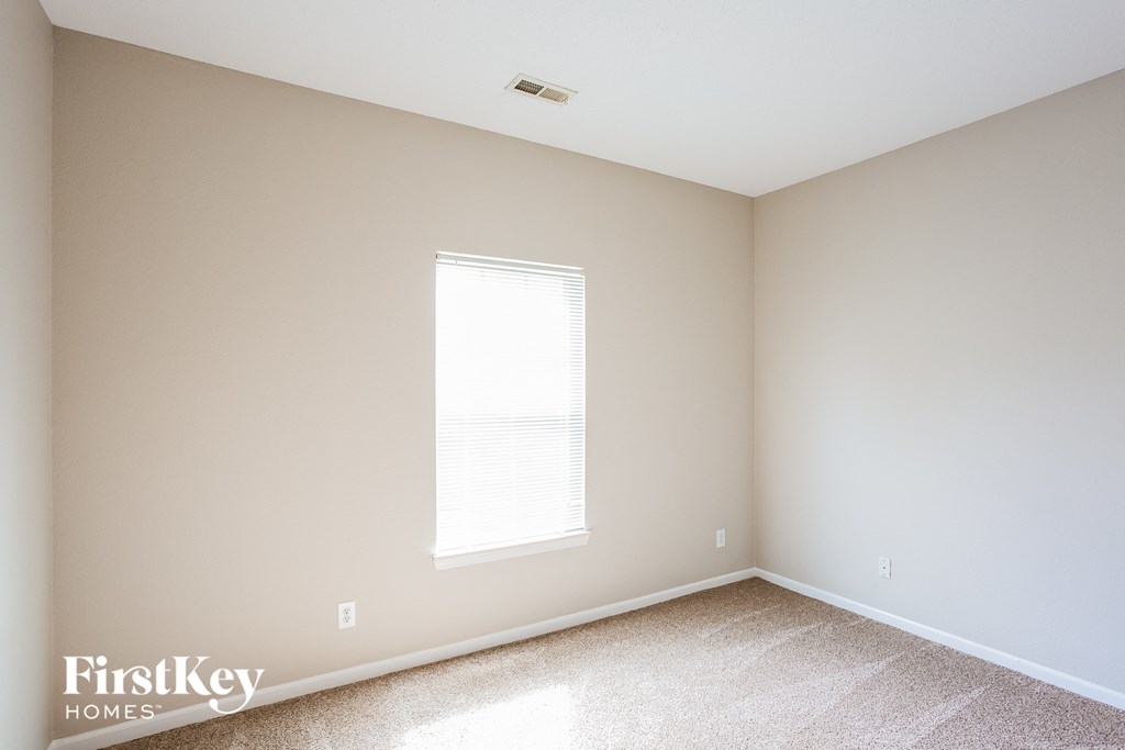 an empty room with white walls and a window