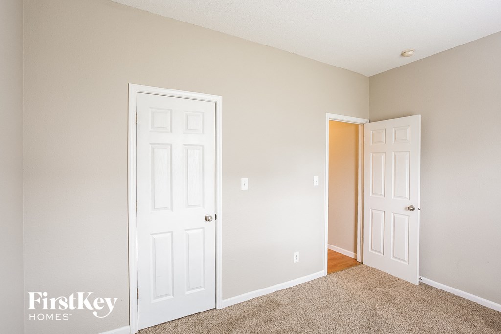 a bedroom with two white doors and a door to a closet