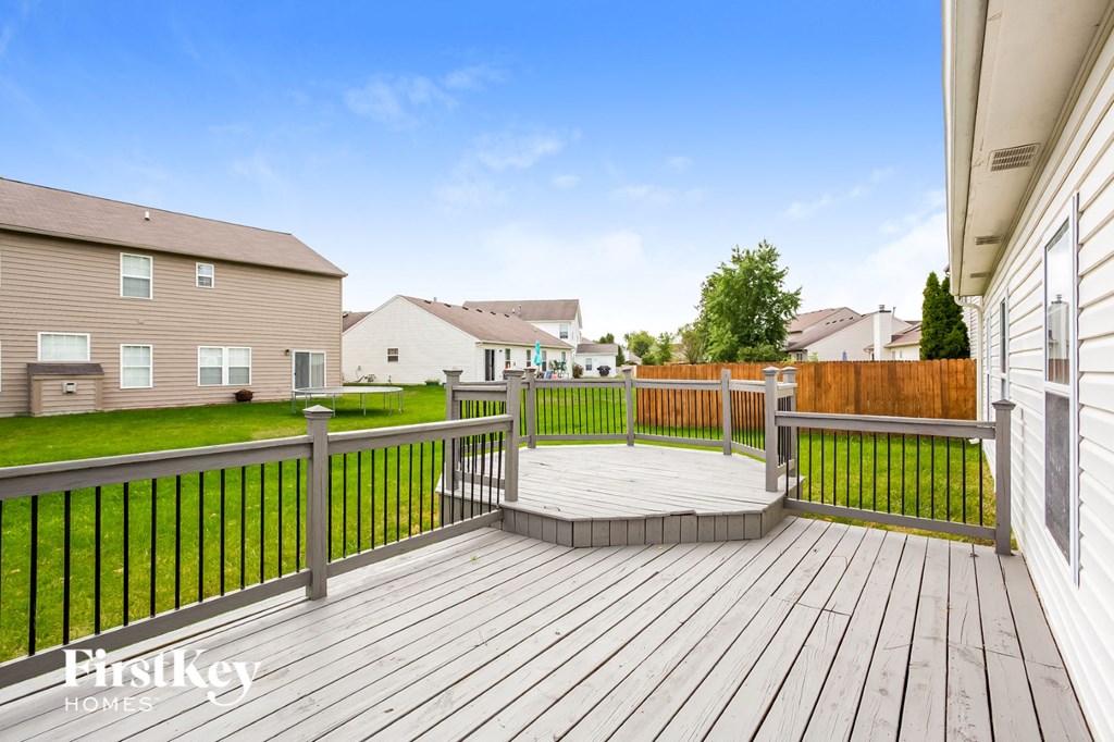 the deck of a home with a yard and a fence