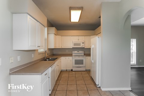 a kitchen with white cabinets and white appliances
