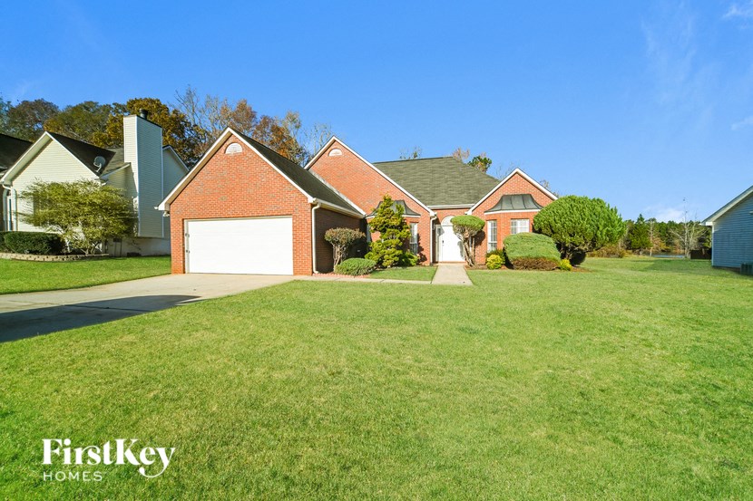 A house with a red brick garage door is for sale.