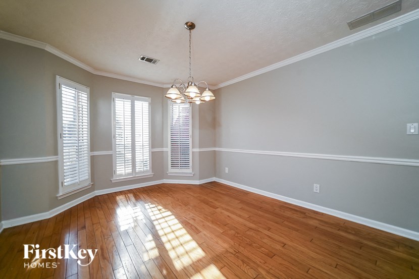 A room with wooden floors and a chandelier hanging from the ceiling.
