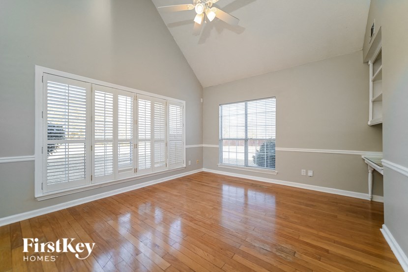 A room with wooden floors and a ceiling fan.