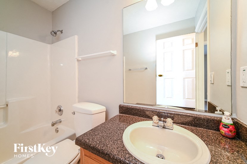 A bathroom with a granite countertop and a white sink.