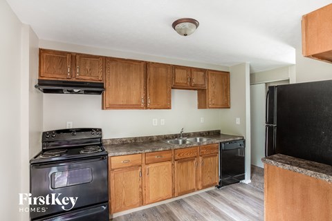 A kitchen with wooden cabinets and a black stove top oven.