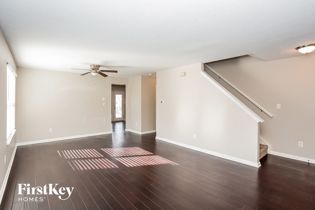 the living room with hardwood flooring and a ceiling fan