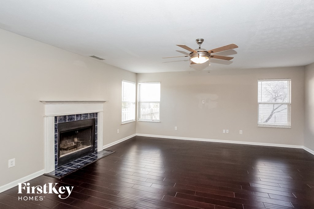 a living room with a fireplace and a ceiling fan