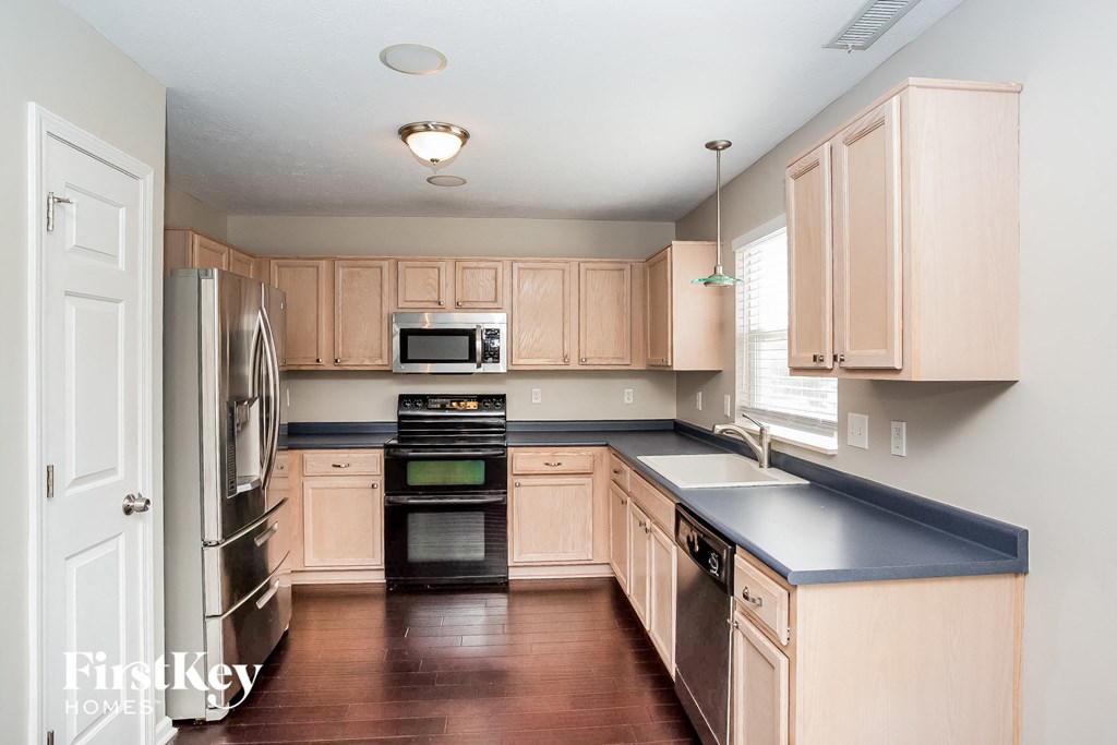 a kitchen with wooden cabinets and stainless steel appliances and black counter tops