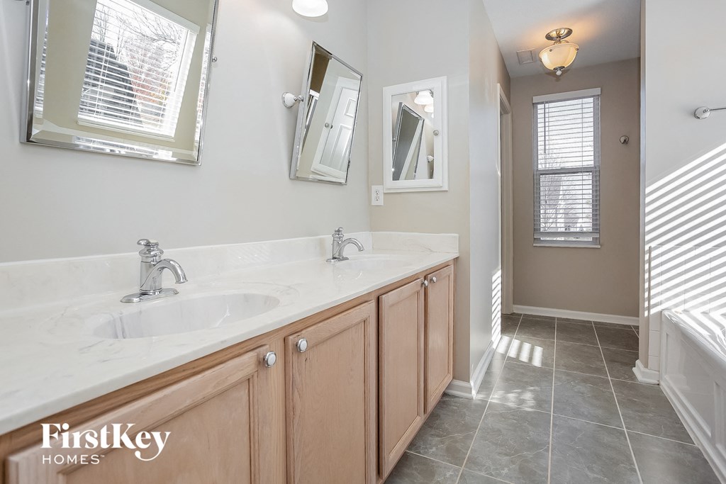 a bathroom with two sinks and two mirrors in it