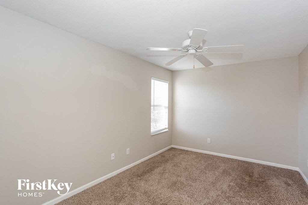 a bedroom with carpet and a ceiling fan