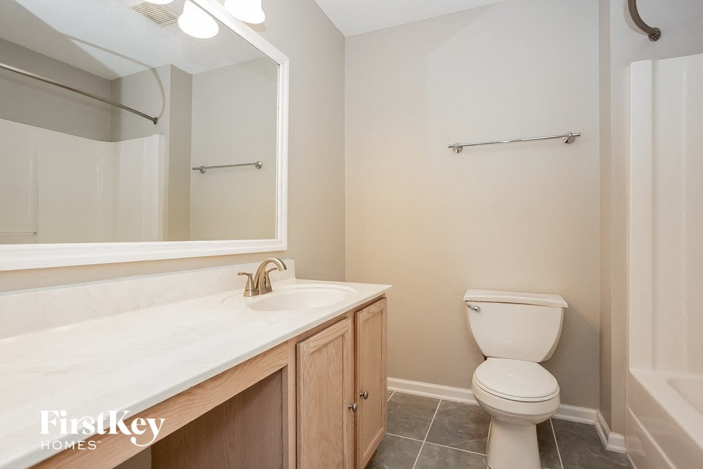 a bathroom with a toilet and a sink and a mirror