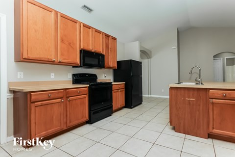 A kitchen with wooden cabinets and black appliances.