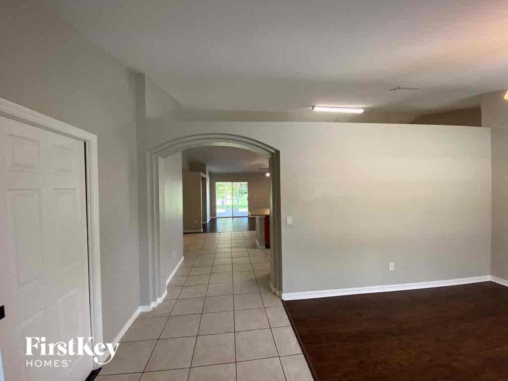 A hallway with a white door and a mirror on the wall.