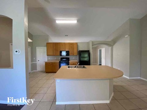 A kitchen with a white counter and wooden cabinets.