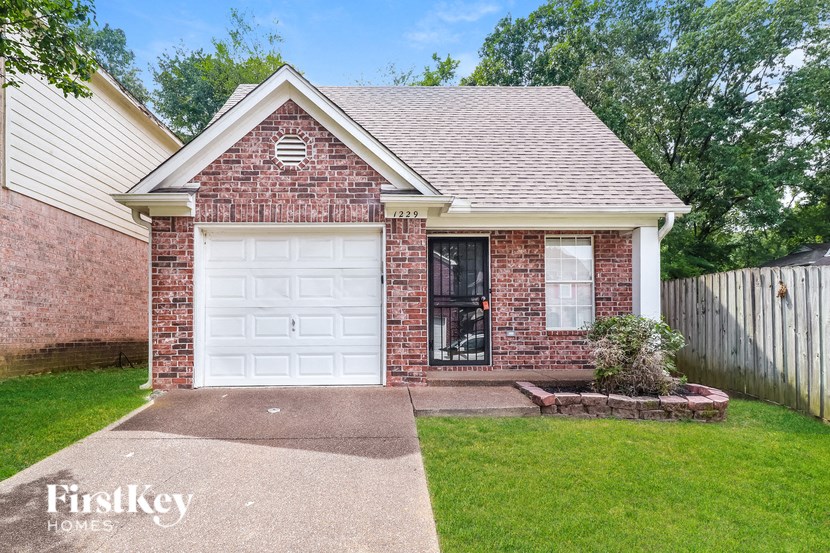 a small brick house with a white garage door