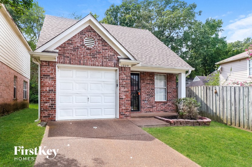 a small brick house with a white garage door