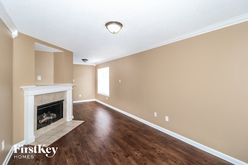 a living room with a fireplace and wooden floors