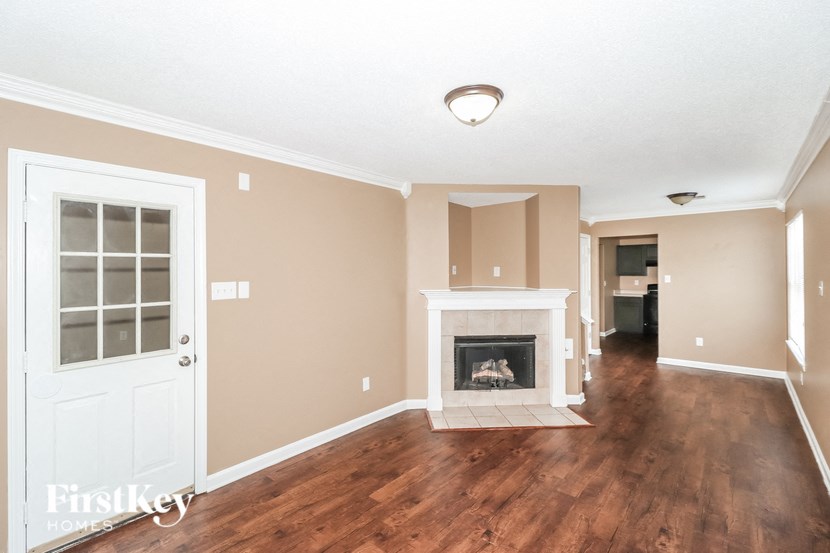 a living room with a fireplace and a white door