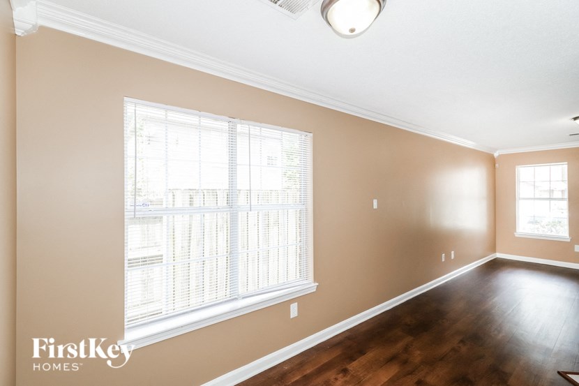 a living room with a large window and wooden floors