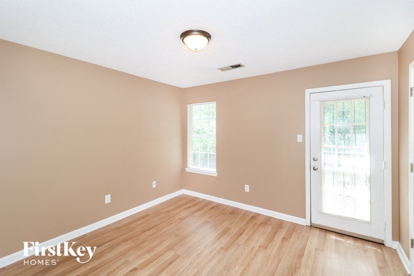 the living room with wood floors and a white door