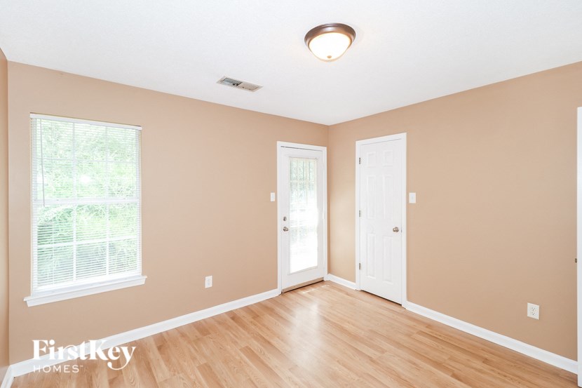 an empty living room with wood floors and a white door
