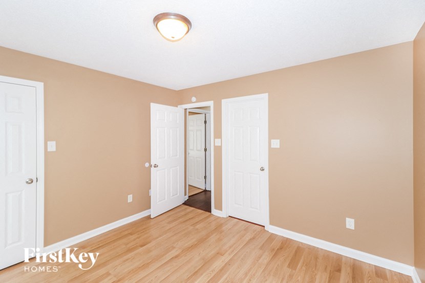 the living room of an empty house with wood floors and two doors