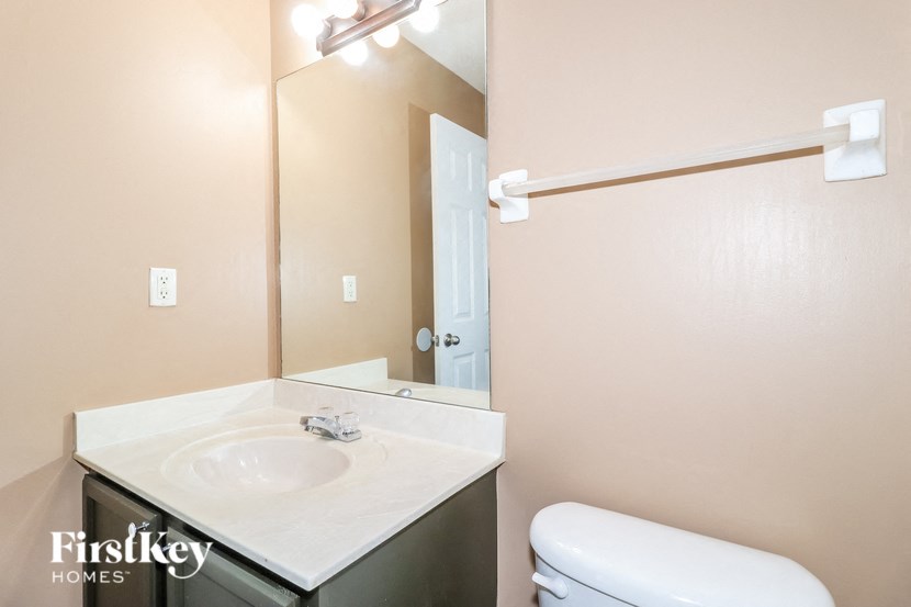 a bathroom with a sink toilet and a mirror