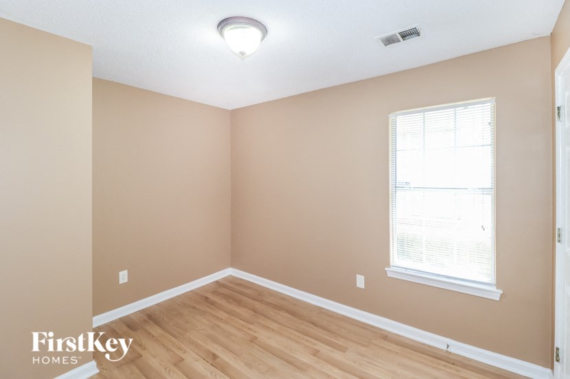 the living room of a home with wood floors and a window