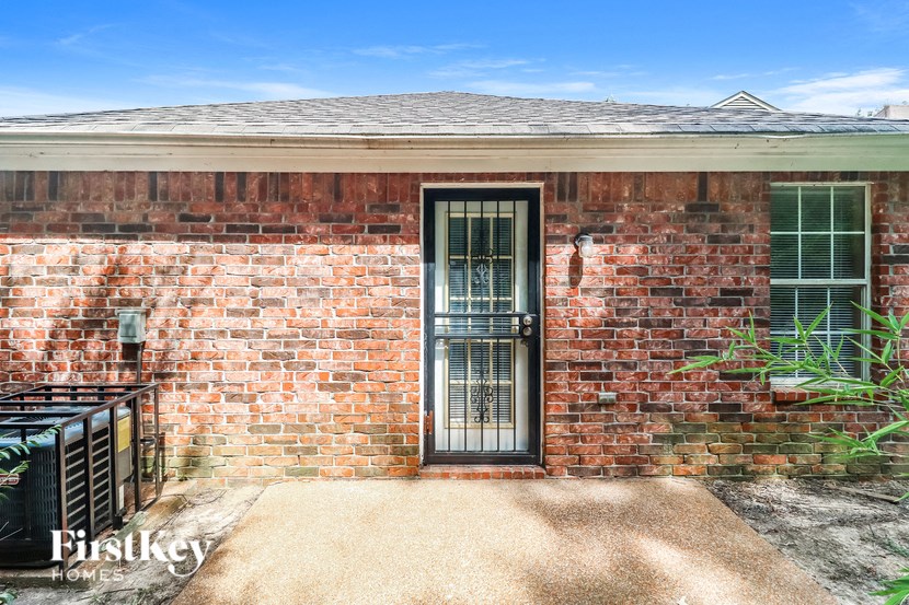 the front door of a brick house with a gate