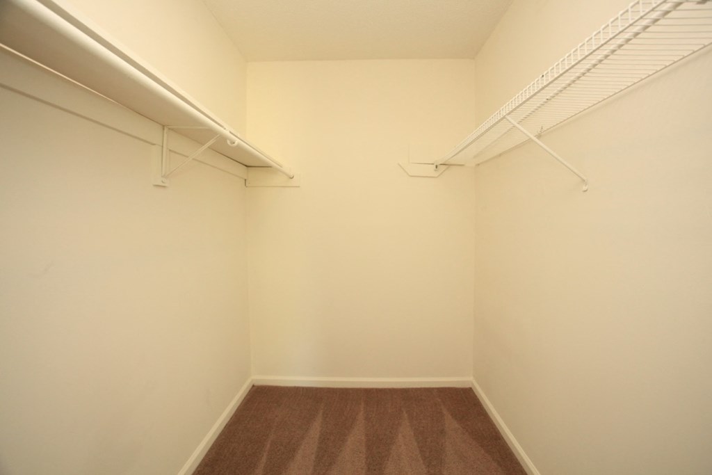 an empty room with white walls and two white shelves on the wall