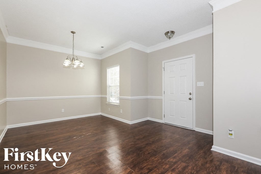 an empty living room with wood floors and a white door