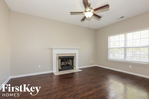 a living room with a fireplace and a ceiling fan