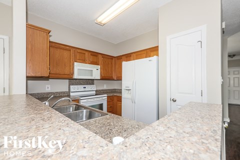 a kitchen with granite counter tops and white appliances
