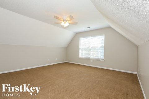 a bedroom with a carpeted floor and a ceiling fan