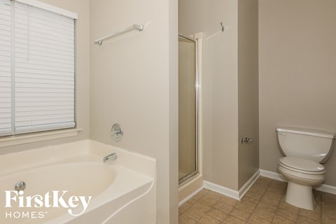 a bathroom with a toilet and a tub and a shower
