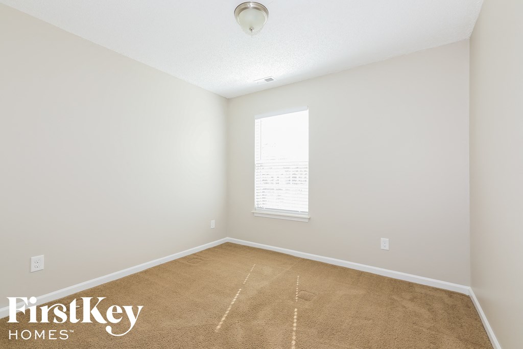 a bedroom with a carpeted floor and a window