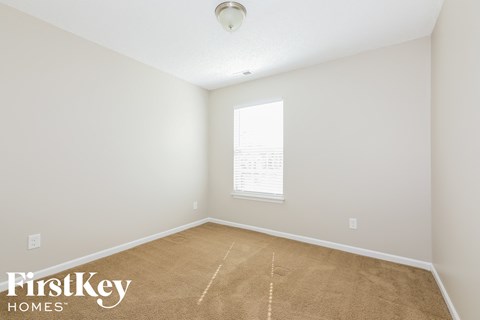 a bedroom with a carpeted floor and a window