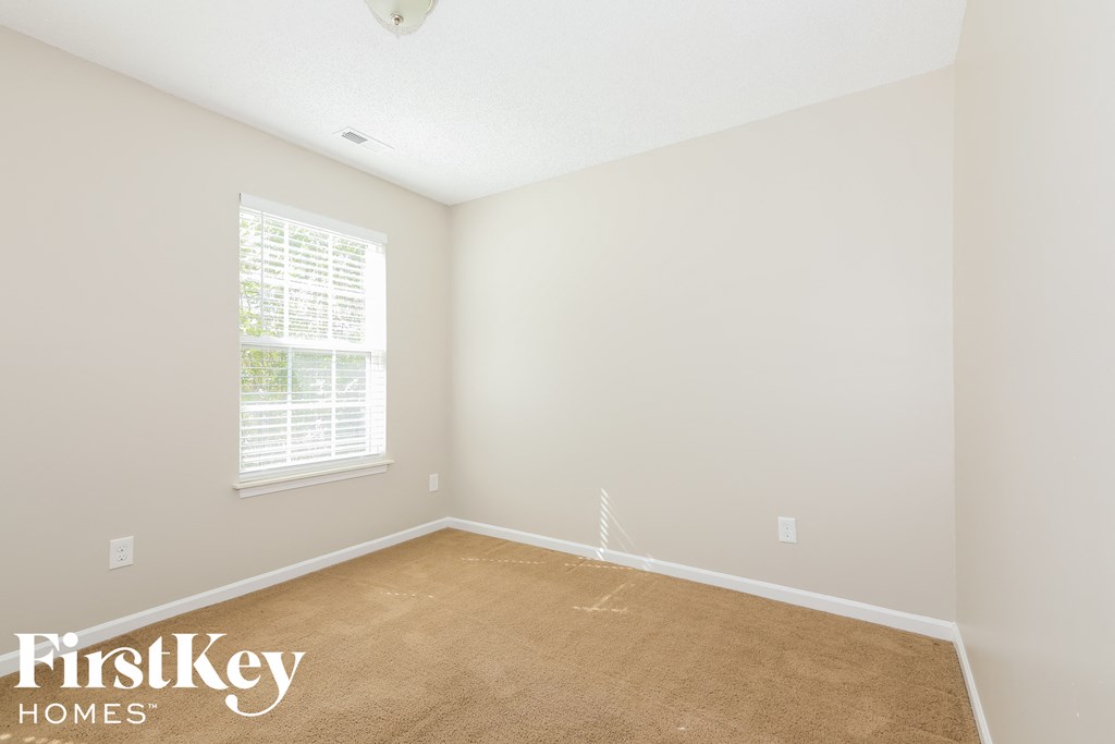 a bedroom with a carpeted floor and a window