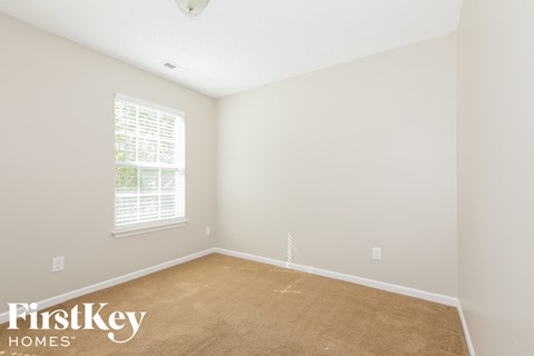 a bedroom with a carpeted floor and a window