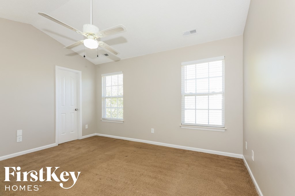 a bedroom with a carpeted floor and a ceiling fan