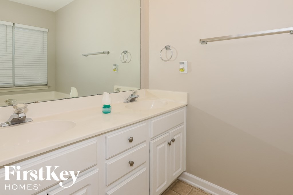 a white bathroom with two sinks and a large mirror