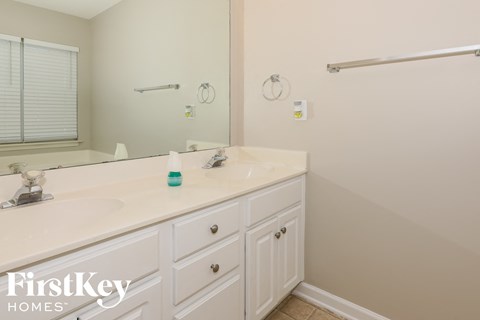 a white bathroom with two sinks and a large mirror