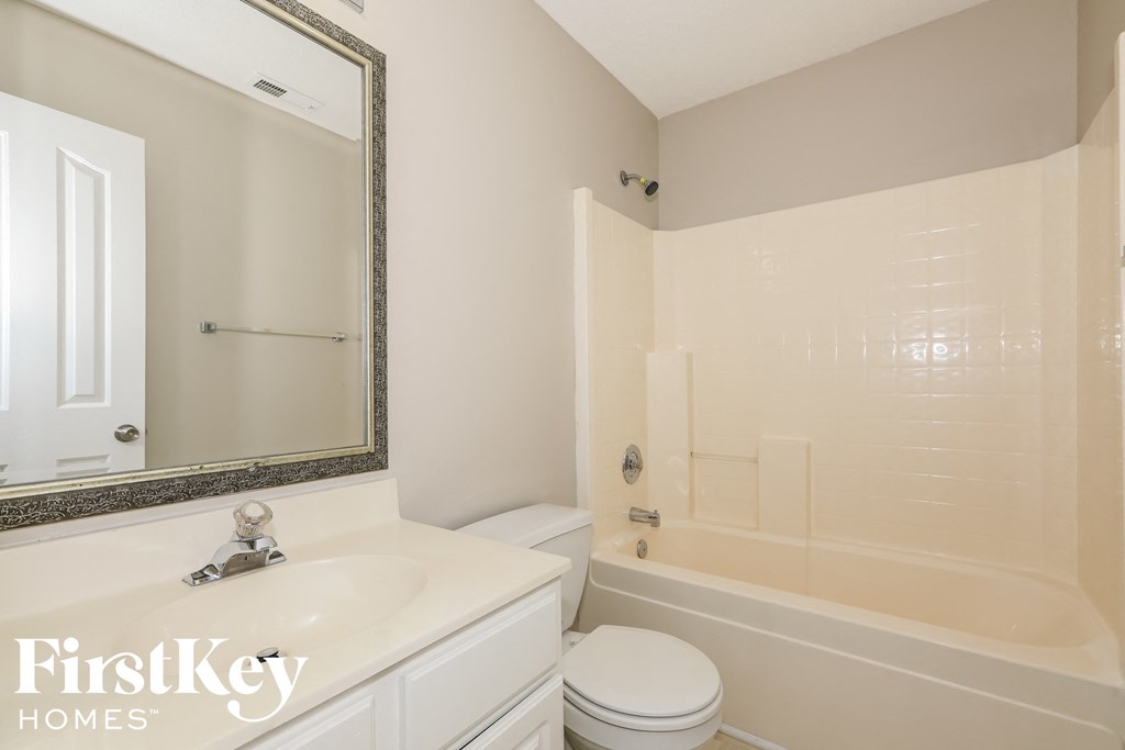 a white bathroom with a tub and a sink and a toilet