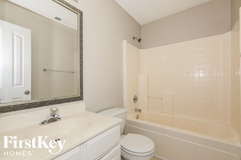 a white bathroom with a tub and a sink and a toilet