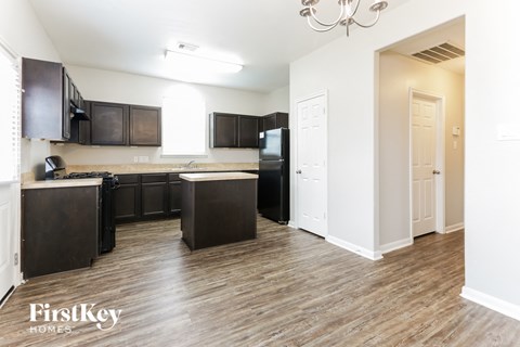 A kitchen with dark wood cabinets and a white door.